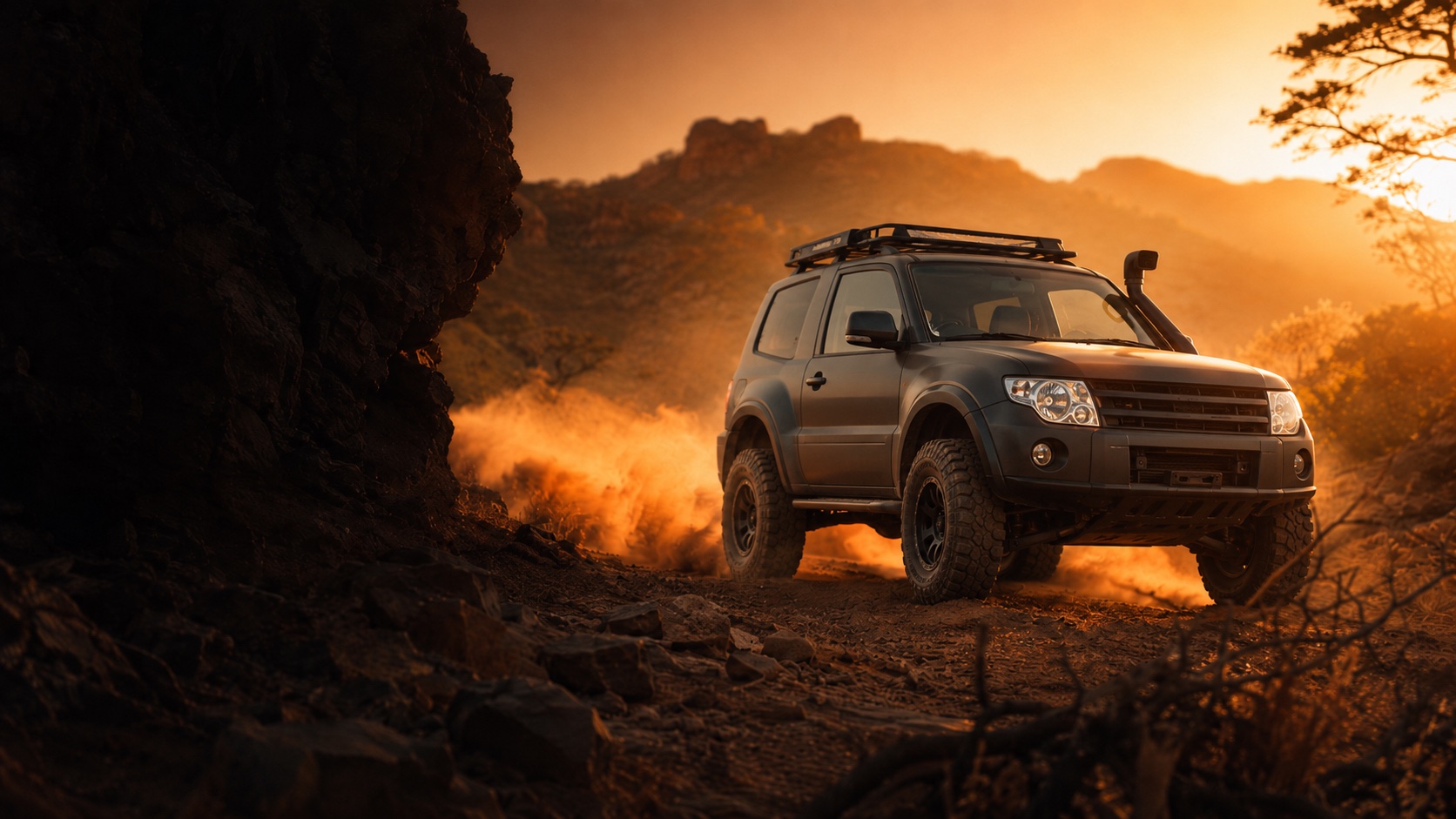 Mitsubishi Pajero 4x4 tackling a rocky red African bush trail at golden hour, dust rising beneath all-terrain tyres