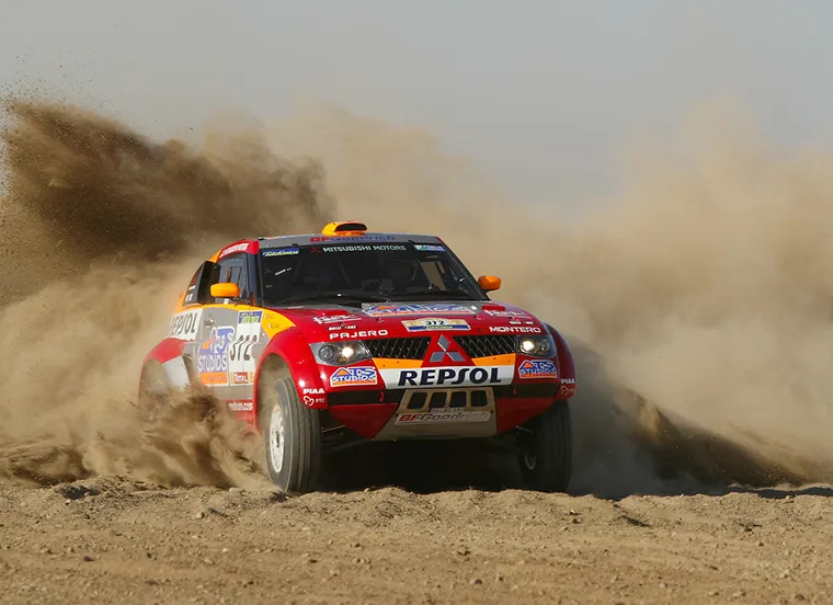 2005 Mitsubishi Pajero Evolution throwing up a cloud of dust on the Dakar Rally