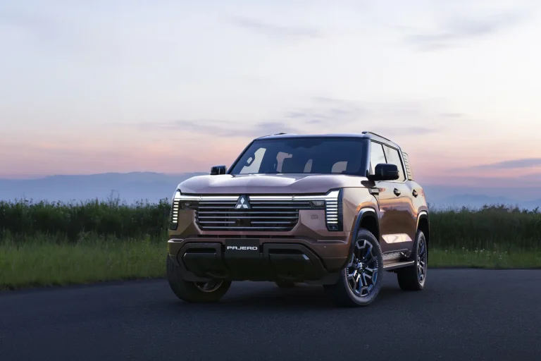 New Mitsubishi Pajero 2027 seen from the front three-quarter at dusk, showing the vertical LED headlights and upright bonnet